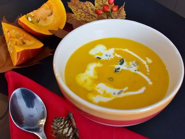 Kürbissuppe daneben liegen Kürbisse